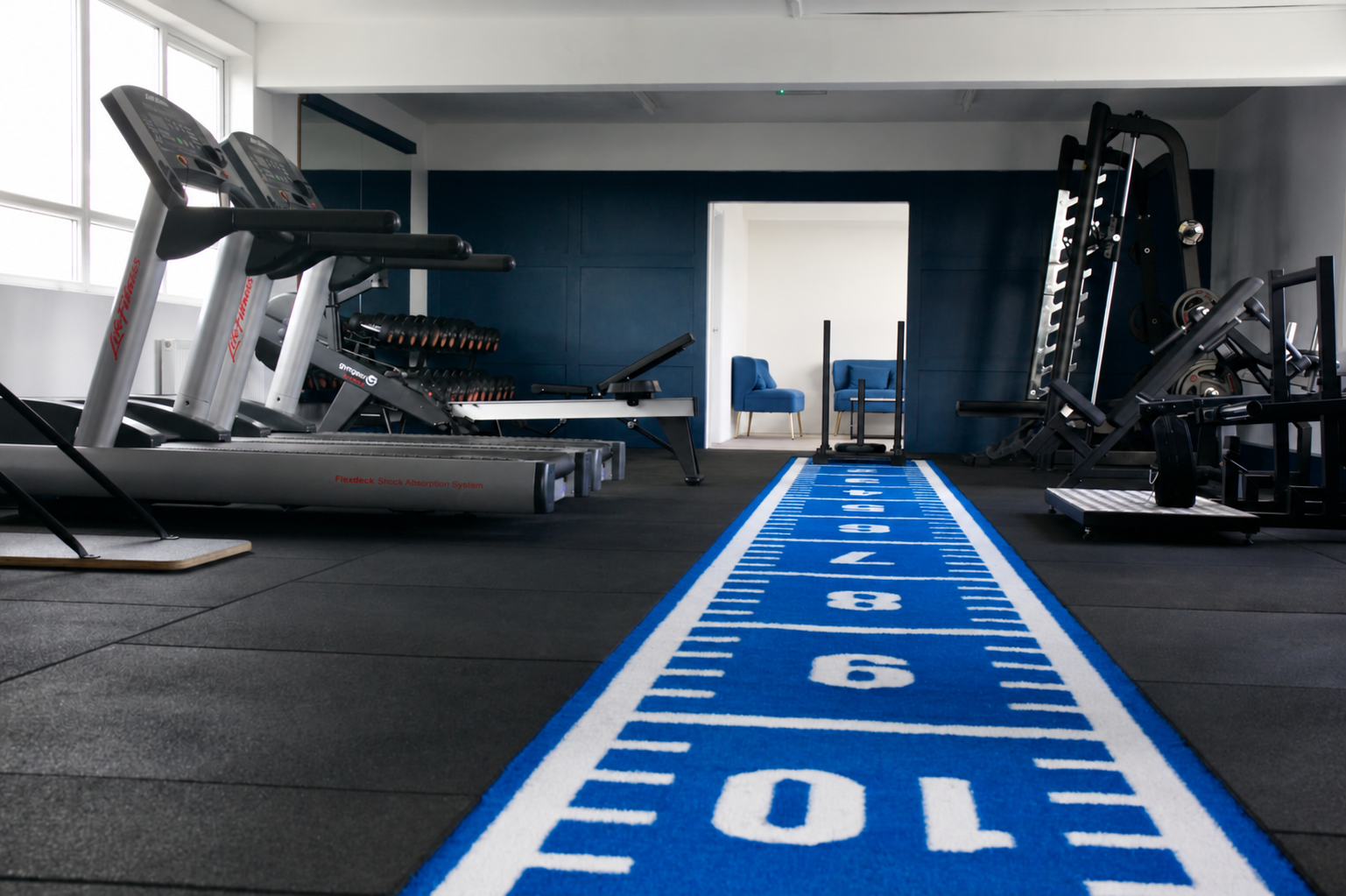 A wide view of the Top Floor Performance gym and blue training track